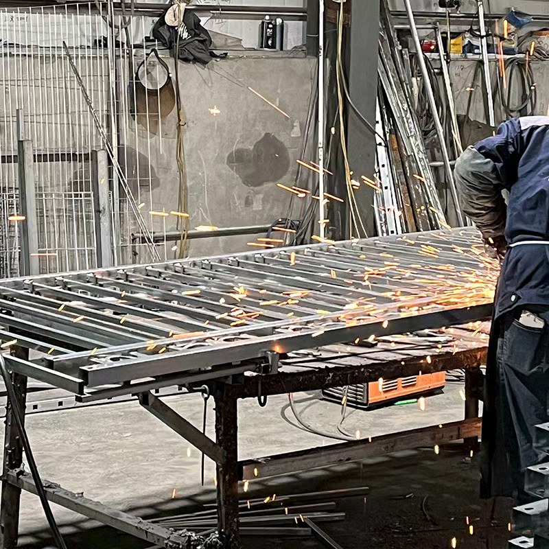 The workers are welding the steel fence